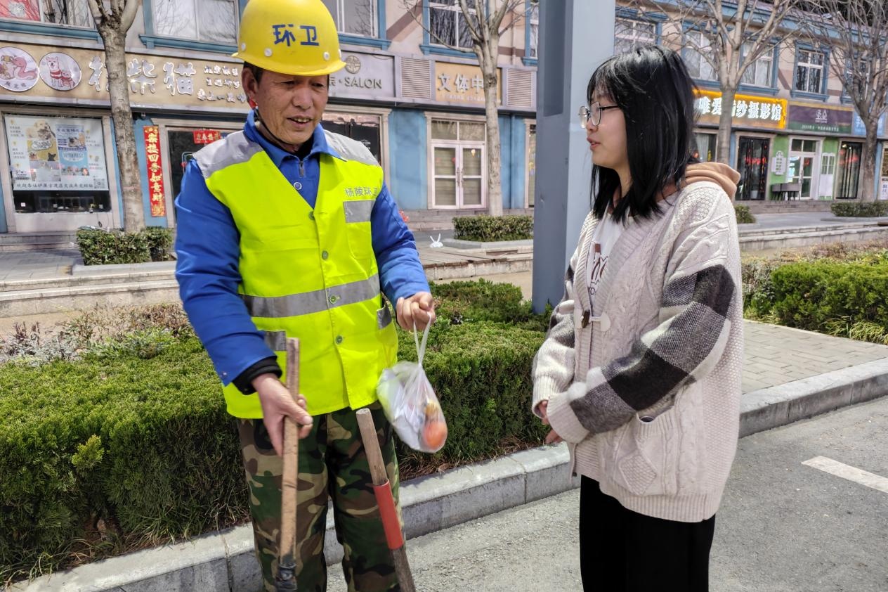 志愿者向环卫工人亲切问候.jpg