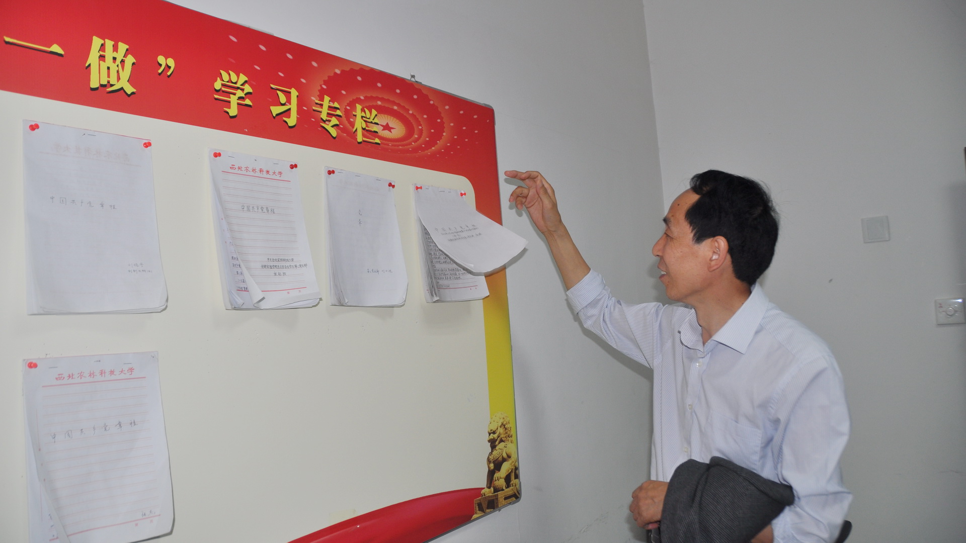 任应坤书记在书院立德坊翻看员工党员手抄党章